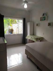 a bedroom with a bed and a table and a window at Casa com Piscina e ampla area de festas in Barra Velha
