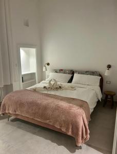 a bedroom with a large bed with two stuffed animals on it at Casina Ada & Niní in Galatina