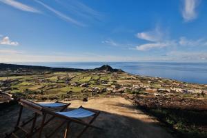 two chairs sitting on top of a hill next to the water at Ca Garsia by KlabHouse Dammuso with 7bdrm and pool in Scauri
