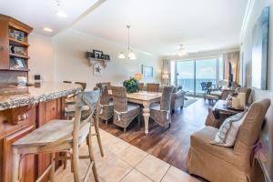 a dining room and living room with a view of the ocean at Boardwalk 1502 in Panama City Beach
