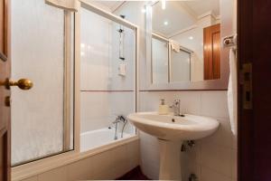 y baño blanco con lavabo y ducha. en Apartamento Princesa Madeira, en Funchal