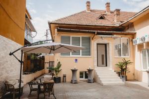 a patio with an umbrella in front of a house at Eden Central Boutique Suites - Garden & Spacious Apartments in Cluj-Napoca