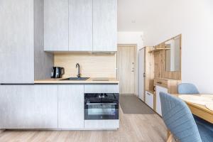 a kitchen with white cabinets and a sink and a table at For new-style always in Palanga