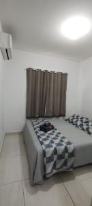 ein Schlafzimmer mit einem Bett mit einer Decke und einem Vorhang in der Unterkunft Apartamento em João Pessoa, bairro Bessa in João Pessoa