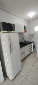 eine weiße Küche mit Kühlschrank und Herd in der Unterkunft Apartamento em João Pessoa, bairro Bessa in João Pessoa + 6 Fotos