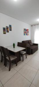 ein Wohnzimmer mit Tisch und Couch in der Unterkunft Apartamento em João Pessoa, bairro Bessa in João Pessoa
