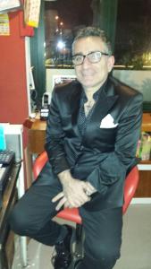 Ein Mann im Anzug, der auf einem Stuhl sitzt. in der Unterkunft B&B Bed& Fly - Mamma Mia in Azzano San Paolo
