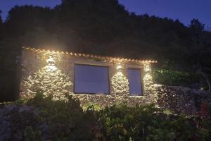 a stone house with lights on it at night at cabaña do rei in Betán