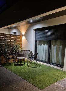 eine Terrasse mit einem Tisch und Stühlen auf einem grünen Teppich in der Unterkunft Love Room - Cocon Room - Toulon - Ollioules in Ollioules