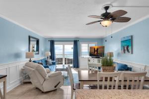 a living room with blue walls and a ceiling fan at Holiday Surf and Racquet Club 319 in Destin