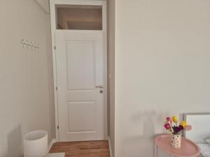 a room with a white door and a table with flowers at Apartman Lončar Posušje in Posušje +24 photos