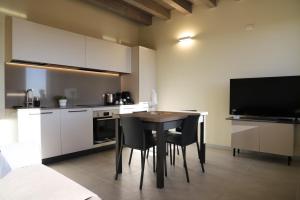 a kitchen with a table with chairs and a television at Stelle di Verona - Andromeda in Verona