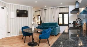 a living room with blue chairs and a table at Parrot’s House in Lloret de Mar