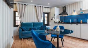 a living room with a blue couch and a table at Parrot’s House in Lloret de Mar