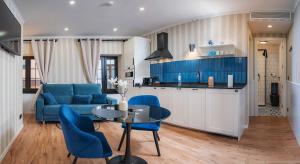 a living room with a blue couch and a table at Parrot’s House in Lloret de Mar