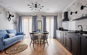 a kitchen with a blue couch and a table and chairs at Parrot’s House in Lloret de Mar