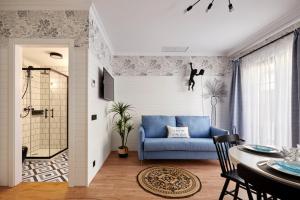a living room with a blue couch and a table at Parrot’s House in Lloret de Mar