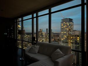 a couch in a room with a view of a city at 44th Floor, Panoramic Views, Bay Corridor Downtown Toronto Condo in Toronto +54 photos