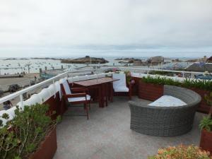 a patio with a table and chairs and the beach at Hôtel - Restaurant - Salon de Thé Le Beauséjour in Trégastel +2 photos