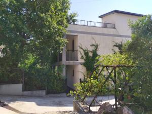 a building with a gate and trees in front of it at Villa Nadija in Čanj
