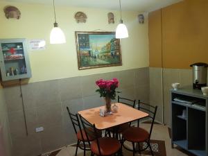 a table with a vase of flowers on it in a kitchen at Hostal Terranova Quitumbe in Quito