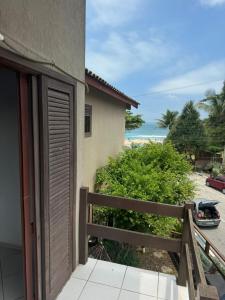 a balcony with a view of the ocean from a house at Quarto lateral da beira mar - tombo - guarujá in Guarujá