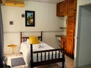 a bedroom with a bed with a yellow pillow on it at Tico Bed & Breakfast La Fortuna in Fortuna