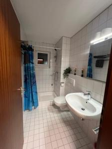 a bathroom with a sink and a toilet and a tub at Apartment Nr 7 am Stuttgarter Flughafen und Messe in Leinfelden-Echterdingen