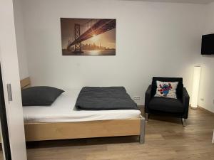 a bedroom with a bed and a chair at Apartment Nr 7 am Stuttgarter Flughafen und Messe in Leinfelden-Echterdingen