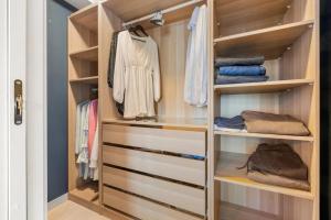 a walk in closet with wooden shelves at Demims Apartments Lillestrøm City Centre - Parking in Lillestrøm