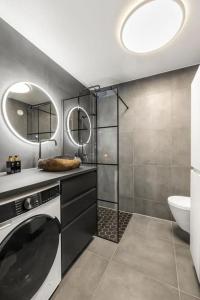 a bathroom with a washing machine and a sink at Demims Apartments Lillestrøm City Centre - Parking in Lillestrøm