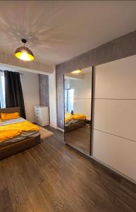 Un dormitorio con una cama y un espejo grande. en Apartament Central Craiova, en Craiova
