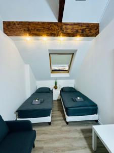 a room with two beds and a couch and a mirror at Apartment 3 in Pulheim