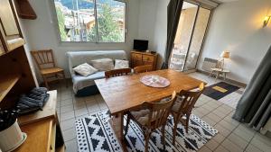 a living room with a table and chairs and a couch at Appartement Centre Ville pied de piste Briançon in Briançon
