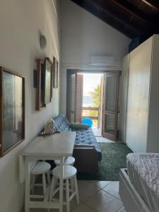 Una sala de estar con un sofá, una mesa y sillas. en Quarto beira mar - tombo - guarujá, en Guarujá