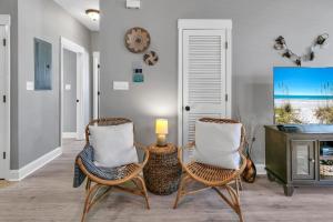 Una sala de estar con dos sillas y un televisor. en Topsail Village 721- Shore Bird Sanctuary, en Santa Rosa Beach