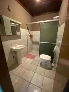 a bathroom with a toilet and a sink at JOÃO CARLOS CASAS 3 Quartos Penha SC in Penha