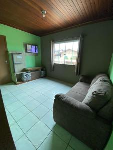 a living room with a couch and a window at JOÃO CARLOS CASAS 3 Quartos Penha SC in Penha +16 photos
