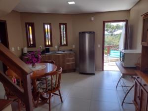 a kitchen with a refrigerator and a table with chairs at Sobrado aconchegante em Nova Petrópolis-RS perto de Gramado in Nova Petrópolis