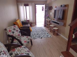 a living room with two chairs and a television at Sobrado aconchegante em Nova Petrópolis-RS perto de Gramado in Nova Petrópolis