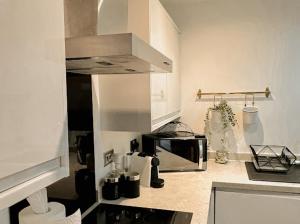 una cocina con estufa y microondas en Mathew Street 1 bed apt sleeps 6, en Liverpool