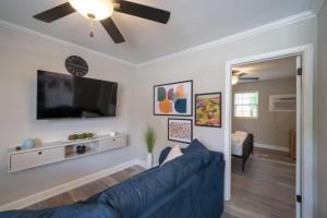 a living room with a blue couch and a flat screen tv at OV Mosaic - Float Suite in North Camellia Acres