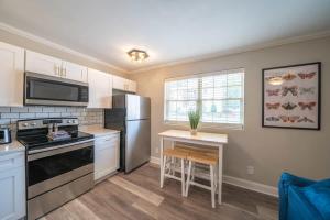 a kitchen with a stove and a refrigerator and a table at OV Mosaic - Float Suite in North Camellia Acres