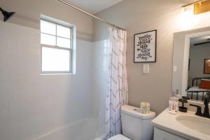 a bathroom with a tub and a toilet and a sink at OV Mosaic - Float Suite in North Camellia Acres +6 photos