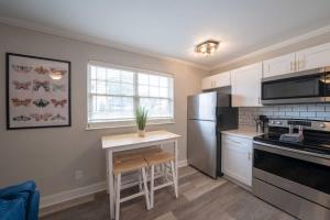 a kitchen with a stainless steel refrigerator and a table at OV Mosaic - Bloom Suite in North Camellia Acres