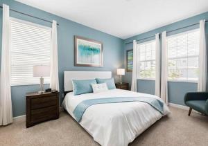 a blue bedroom with a bed and two windows at Stunning Home wPrivate Pool, minutes from Disney in Davenport +60 photos