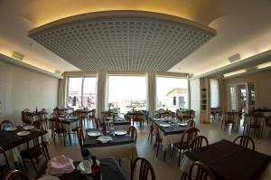 a restaurant with tables and chairs and a large window at Hotel Alba D'Oro in Bellaria-Igea Marina
