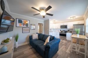 a living room with a blue couch and a kitchen at OV Mosaic - Rain Suite in North Camellia Acres
