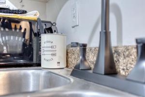 a mug sitting on a kitchen counter next to a sink at Southern Charm 3-0 in Columbus +27 photos