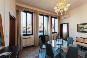 una sala da pranzo con tavolo, sedie e finestre di Residenza Dei Dogi a Venezia